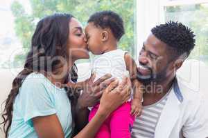 Happy parents with baby girl on couch