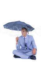Businessman sheltering under umbrella