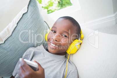 Little boy listening to music on the couch