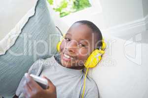 Little boy listening to music on the couch