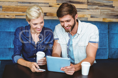 Cute couple on a date watching photos on a tablet