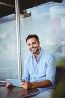 Smiling businessman using a tablet