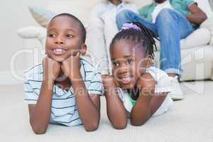 Happy siblings lying on the floor