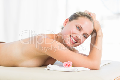 Peaceful blonde lying on towel smiling at camera