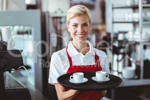 Pretty barista holding two cups of coffee