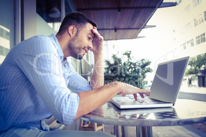 Smiling businessman using his laptop