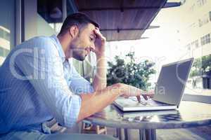 Smiling businessman using his laptop