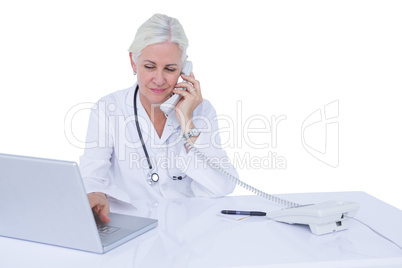 Doctor working on her laptop and on the phone