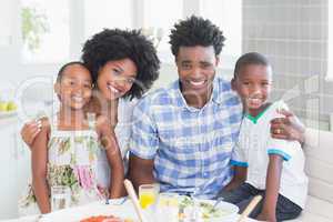 Happy family sitting down to dinner together