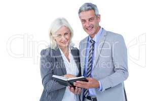 Smiling businesswoman and man with a notebook