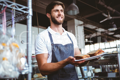 happy worker holding sandwiches