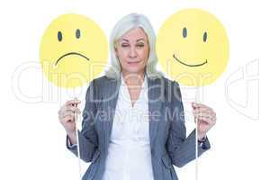 businesswoman holding a sad and a happy smiley