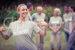 Happy volunteer showing her t-shirt to camera