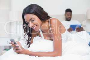 Relaxed couple using technology on bed