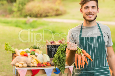 Handsome farmer holding carrots