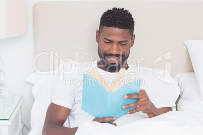 Handsome man reading in bed Handsome man reading in bed