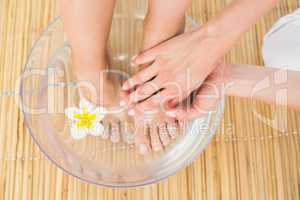 woman washing her feet in a bowl of flower