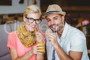 Cute couple on a date sharing an orange juice