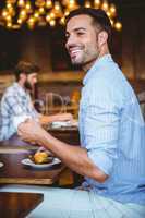 Smiling businessman holding a cup of coffee