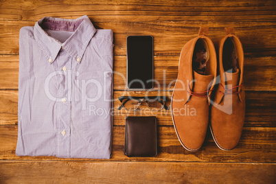 Shirt shoes glasses next to wallet and smartphone