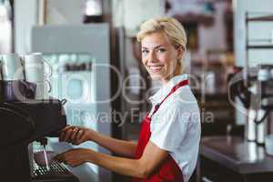 Pretty barista using the coffee machine