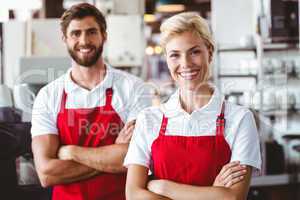 Two baristas smiling at the camera