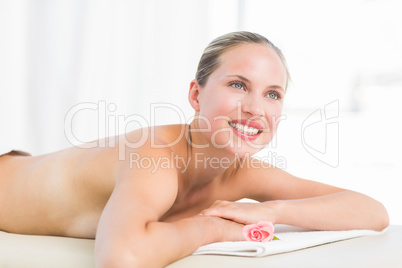 Peaceful blonde lying on towel smiling at camera