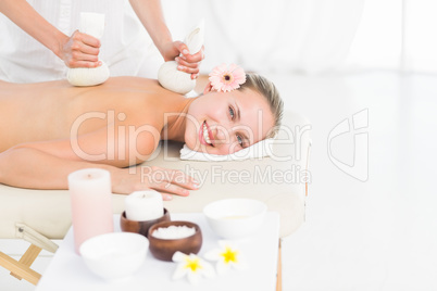 Beautiful blonde enjoying a herbal compress massage Beautiful blonde enjoying a herbal compress massage