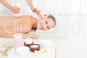 Beautiful blonde enjoying a herbal compress massage