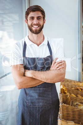 Smiling server in apron arm crossed