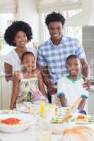 Happy family sitting down to dinner together