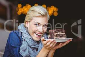 Smiling blonde holding a chocolate cake