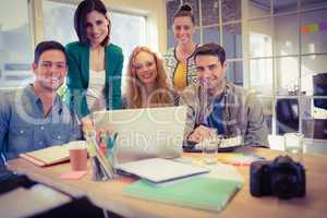 Portrait of smiling casual colleagues using computer