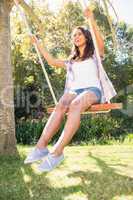 Pretty brunette swinging in park