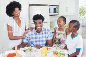 Happy family sitting down to dinner together