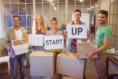 Creative business team holding cardboard written start up