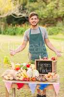 Handsome farmer standing at his stall