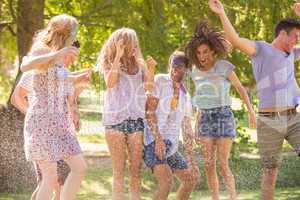 Young friends having fun with hose in the park