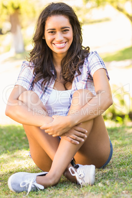 Pretty brunette sitting in the grass