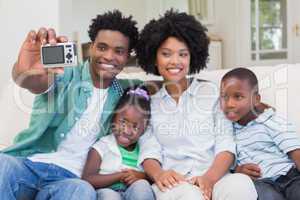 Happy family taking a selfie on the couch