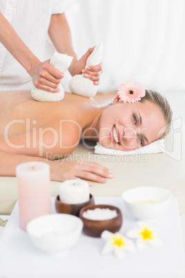 Beautiful blonde enjoying a herbal compress massage Beautiful blonde enjoying a herbal compress massage