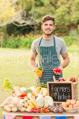 Handsome farmer holding peppers