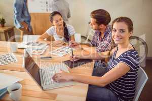 Smiling young businesswoman using laptop
