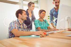 Colleagues using laptop at office