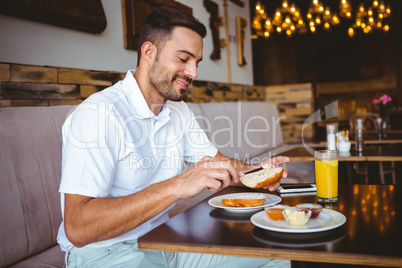 Young man spreading butter on a toast