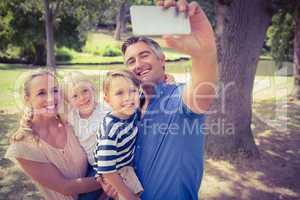 Happy family taking a selfie in the park