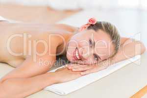 Peaceful blonde lying on towel smiling at camera