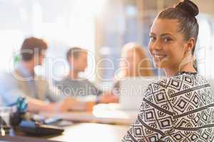 Portrait of smiling young businesswoman with colleagues