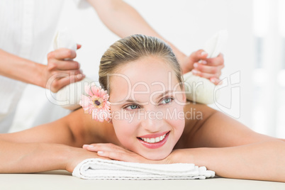 Beautiful blonde enjoying a herbal compress massage