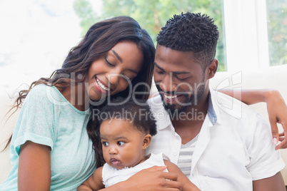 Happy couple with their baby girl on couch Happy couple with their baby girl on couch